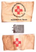 A Third Reich Red Cross OR’s belt buckle, together with arm band and another arm band of the
