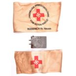 A Third Reich Red Cross OR’s belt buckle, together with arm band and another arm band of the