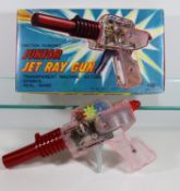 A 1960's Japanese K.O. Junior Jet Ray Gun. In clear and red plastic, with a friction powered