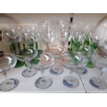 A collection of wine glasses with coloured stems and Babycham glasses