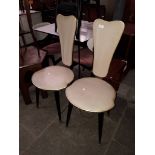 A pair of retro high back chairs on spindle legs