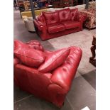 A two piece red leather Chesterfield style suite.