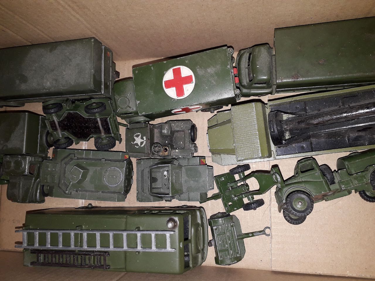 A box of Dinky military model vehicles.