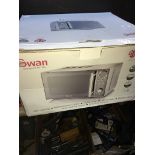 A boxed and unused Swan 20L capacity microwave.
