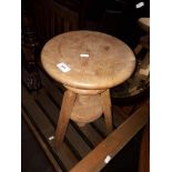 An adjustable blonde elm stool