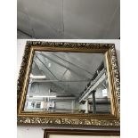 A gold framed bevelled edge mirror