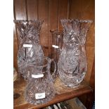 A pair of cut glass vases, and two cut glass jugs.