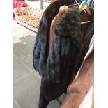 A 3/4 long fur coat, a faux fur coat and a brown leather coat.