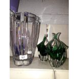 A large glass vase and two small green vases