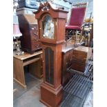 A modern reproduction long case clock with brass dial