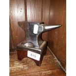 A small steel anvil on wooden stand