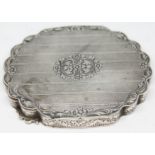 A 19th century continental silver compact with shaped edge, engraved floral border and central
