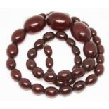 A single strand of graduated cherry amber coloured bakelite beads, ranging from 11mm - 25mm,