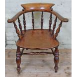 A 19th century elm seated spindle back captain's chair.