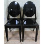 A pair of Victoria Ghost black plastic chairs designed by Philippe Starck for Kartell.