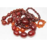 A single strand of cherry bakelite graduated beads and two others.