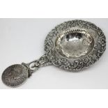 A Dutch embossed silver tea strainer with coin handle, Schoonhoven 1891, length 15cm, wt. 60.24g.