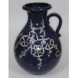 A West German pottery vase decorated with cream flowers on blue ground, height 47cm.