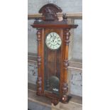 A 19th century walnut cased Vienna wall clock with eagle top, finials and fluted columns, with