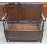 A 1920s oak settle, width 108cm, depth 40cm & height 107cm.