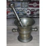 A brass mortar and pestle, height of mortar 10.5cm, length of pestle 21cm.