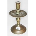 A 16th/17th century dutch brass candle stick with domed circular base, turned stem with broad drip