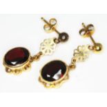 A pair of hallmarked 9ct gold drop earrings, each set with an oval cut garnet, length 26mm, gross