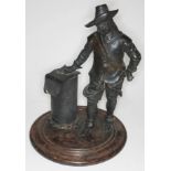A bronze figure of Oliver Cromwell on round wooden base, height 36cm, diameter of base 27cm.