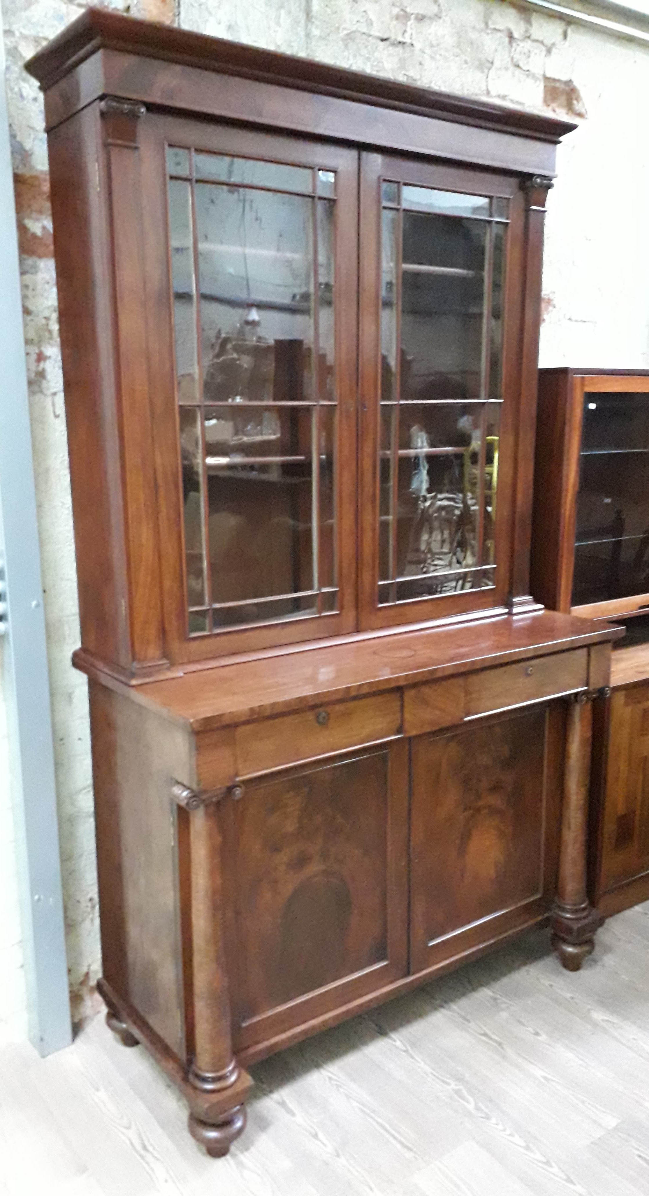 An early Victorian mahogany cabinet bookcase, the top section with cornice, glazed doors and faux