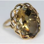 A hallmarked 9ct gold ring set with an oval cut smokey quartz, gross wt. 4.98g, size W.