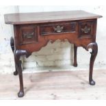 A George II oak low boy with three drawers having brass handles, shaped frieze and cabriole legs