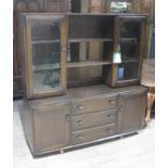 An Ercol dark elm sideboard, the top section with central open cabinet and shelf flanker either side