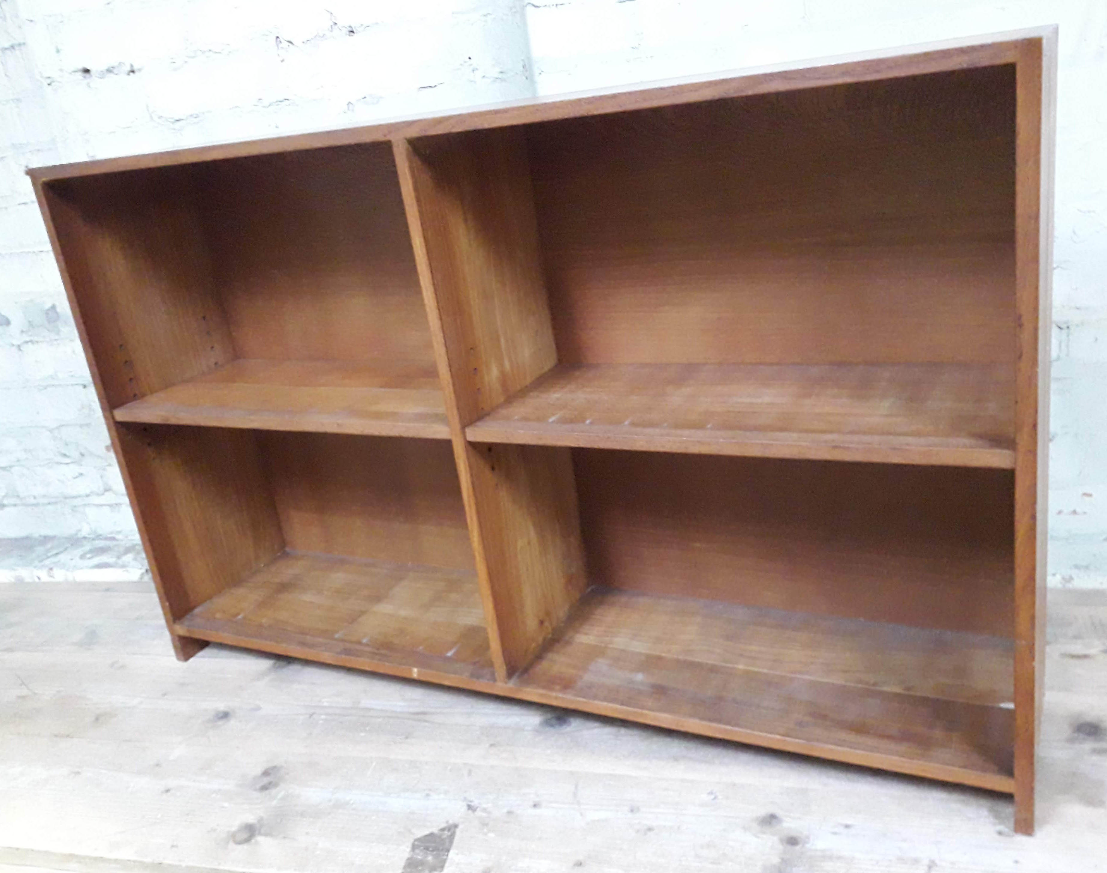 An open oak bookcase with visible dovetail/mortise and tenon joints and two adjustable shelves,