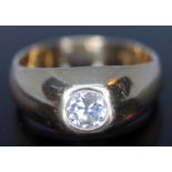 An 18ct gold diamond ring, the central gypsy set round brilliant cut diamond approx. 0.65 carats,