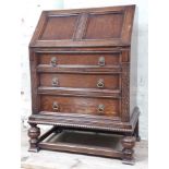 A 1930s carved oak bureau with fitted interior, width 49cm & height 106cm.