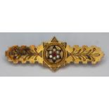 A late Victorian hallmarked 9ct gold brooch set with red paste and split pearls, length 40mm,