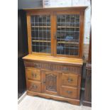 An Edwardian cabinet bookcase with leaded glass top and Art Nouveau style handles, width 121.5cm,