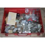 A red metal box containing various GB and world coins.