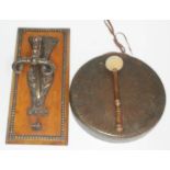 A brass gong, on early 20th century brass mounted hook on wooden plinth decorated with mythical