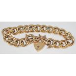An Edwardian link bracelet with heart shaped lock and twelve of the links embossed with scrolls,