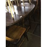 An oak gate leg table and four wheel back chairs.