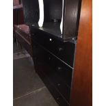 A black desk and black chest of drawers