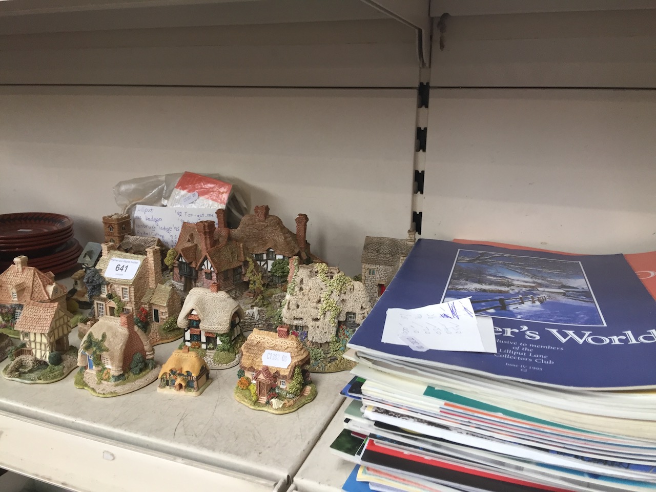 A collection of Lilliput Lane cottages and related collector's magazines.