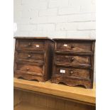 A pair of rustic miniature wooden chests of drawers.