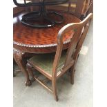 A mahogany round dining table with gadrooned edge on claw and ball feet and a set of 4 splat back