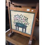 A wood and painted canvas fire screen