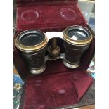 A pair of opera glasses with white metal embossed Egyptian style decoration.