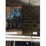 A metal bound wood chess board with military themed copper chess pieces