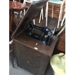 A Singer sewing machine in a stand, with iron pedal.