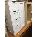 A white painted bathroom cabinet.